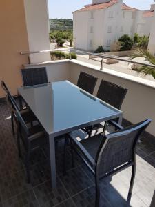 un tavolo e sedie su un balcone con vista di Apartment Novalja 4+2 a Novalja (Novaglia)