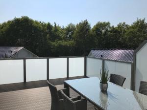 a patio with a table and chairs on a deck at Ferienhaus Rosi in Kiel