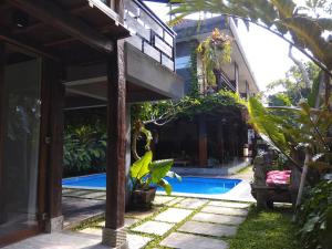 an external view of a house with a swimming pool at Kencana Ubud by Mahaputra in Ubud