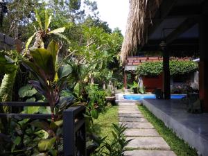 een tuin voor een huis met een zwembad bij Kencana Ubud by Mahaputra in Ubud