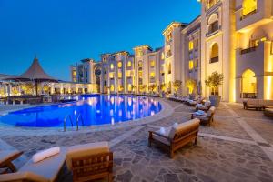 a large swimming pool in front of a building at Ezdan Palace Hotel in Doha