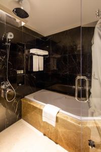 y baño con bañera y ducha. en Ezdan Palace Hotel, en Doha