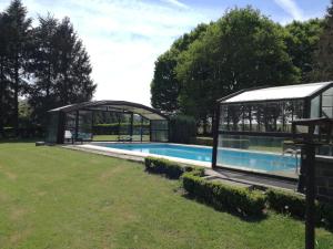 una casa con piscina y una casa de cristal en La Bergerie de Lives, en Namur