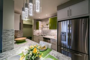 una cocina con nevera y una mesa con flores. en Mckinnon Pointe #104, en Edmonton