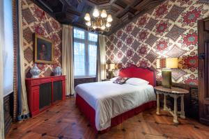 una camera con un letto in una stanza con carta da parati floreale di La Maison Des Vieux Logis a Rouen