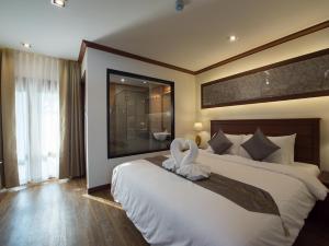 a bedroom with a large bed with a large window at Lanna Tree Boutique Hotel in Chiang Mai