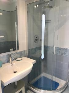 a bathroom with a glass shower and a sink at Casa Celeste in Viareggio