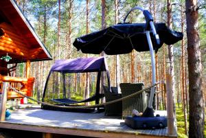 a swing set on a deck in the woods at Kettu Holl Cottage in Taipalsaari