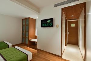 a room with two beds and a door with a sign at Hotel Leafio Marigold-Near Airport in Mumbai