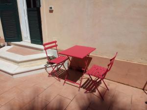 トロペアにあるEmmevvìの赤いテーブルと椅子が備わるパティオ