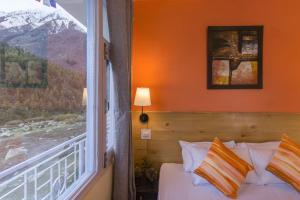 a bedroom with a bed and a large window at Zostel Chitkul in Chitkul