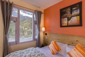 a bedroom with a bed and a window at Zostel Chitkul in Chitkul