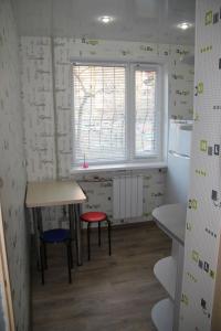 a kitchen with two stools and a table and a window at Современная 1-комнатная квартира in Kharkiv