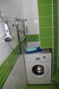 a green and white bathroom with a washing machine at Современная 1-комнатная квартира in Kharkiv