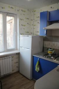 a kitchen with a white refrigerator and blue cabinets at Современная 1-комнатная квартира in Kharkiv