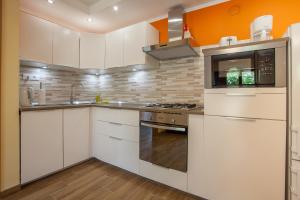 a kitchen with white cabinets and a stove top oven at Apartment Dunja in Cres