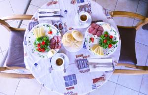 a table with plates of food and cups of coffee at Hotel West in Blagoevgrad