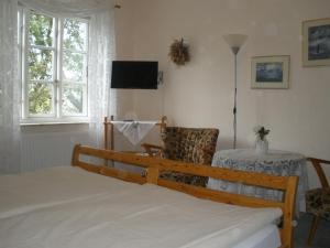 a bedroom with a bed and a chair and a table at Pension Peterswarft in Dagebüll