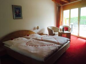 een slaapkamer met een bed met rode loper bij Wellnesshotel Liun B&B in Müstair
