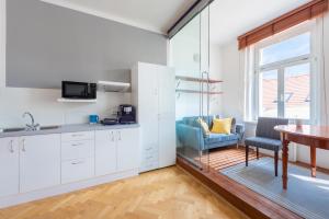a kitchen with white cabinets and a table and a chair at Modern apartment few steps from centre in Prague