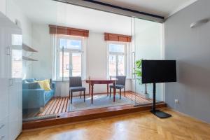 a living room with a table and chairs and a tv at Modern apartment few steps from centre in Prague