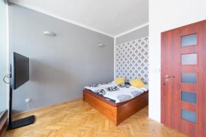 una camera con letto, TV e porta di Modern apartment few steps from centre a Praga