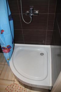 y baño con ducha y aseo blanco. en Современная 1-комнатная квартира en Járkov