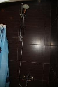 a shower in a bathroom with a brown tiled wall at Современная 1-комнатная квартира in Kharkiv