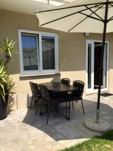 a table and chairs under an umbrella on a patio at Apartments Marjana in Portorož
