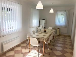 a dining room with a table and white chairs at Geri Apartman in Mezőkövesd