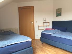 two blue beds in a room with a door at Kleine Wohnung mit Terrasse in Dülmen