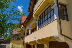 a yellow house with a brown garage at Arina Villa in Hévíz