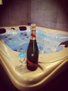 una bottiglia di champagne e due bicchieri di vino in una vasca di Autrement Spa a Avelin