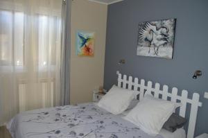 a bedroom with a bed with white sheets and a window at a2pasdelaforet in Morcenx