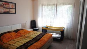 a bedroom with a bed and a desk and a window at Ferienwohnung ,,Wingertsberg" in Ebrach