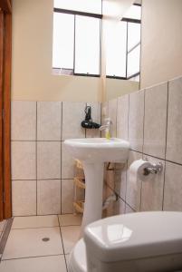 a bathroom with a sink and a toilet and a mirror at B&B Valcava in Urubamba