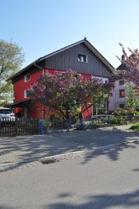 ein rotes Gebäude mit einem Baum mit rosa Blumen in der Unterkunft Punkrock Harbour Pension Bähr in Karlsruhe