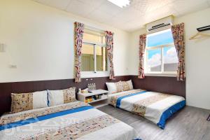 sypialnia z dwoma łóżkami i oknem w obiekcie Xiang Ting Homestay w mieście Magong