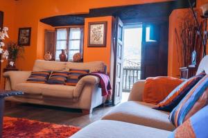 a living room with orange walls and a couch at La Corrolada in Avín