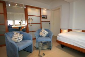 a hotel room with a bed and two chairs and a table at Hanseat in Helgoland