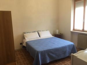 1 dormitorio con 1 cama con manta azul y ventana en Casa Salice, en Racconigi