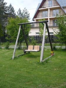 a swing in the grass in front of a house at Pokoje gościnne w górach in Kościelisko