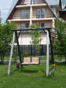 a swing in the grass in front of a house at Pokoje gościnne w górach in Kościelisko