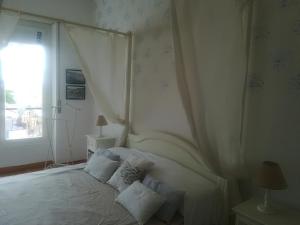 a bedroom with a white bed with pillows and a window at Appartamento Bellavista con parking privato, a un passo dal Teatro Ariston in Sanremo
