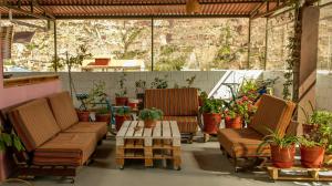 a patio with two chairs and a table and potted plants at B&B Valcava in Urubamba