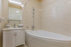 ein weißes Badezimmer mit einer Badewanne und einem Waschbecken in der Unterkunft L'Argamak in Samarkand