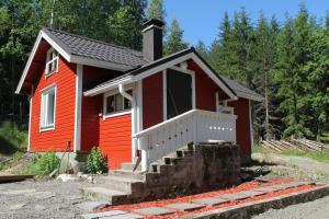a small red house with a staircase in front at Metsäpirtti in Kolinkylä