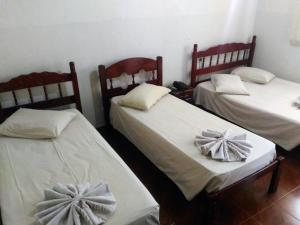 a room with two beds with bows on them at Hotel Cristal in Barra Bonita