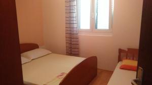 a small room with a bed and a window at Apartment Ružica in Zubovići