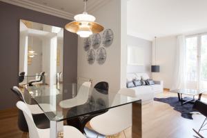 a dining room with a glass table and white chairs at Rent Top Apartments Avenida Diagonal in Barcelona